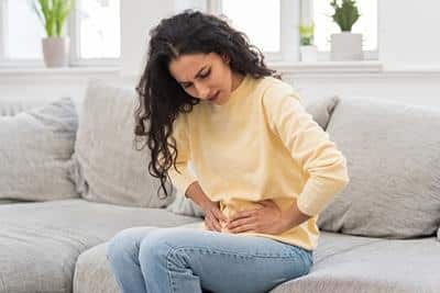 woman with hands over lower abdomen