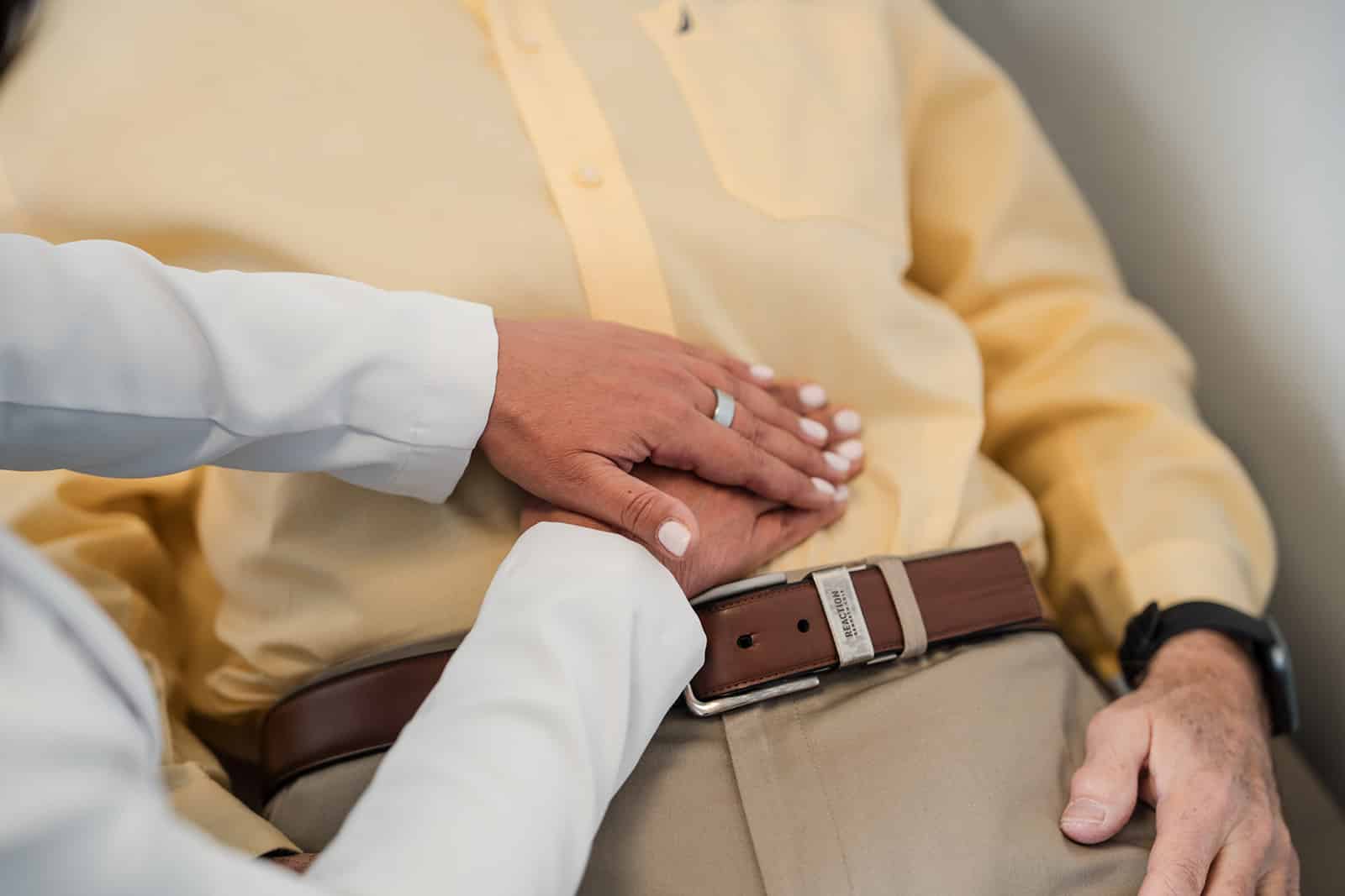 doctor's hands on patient's abdomen