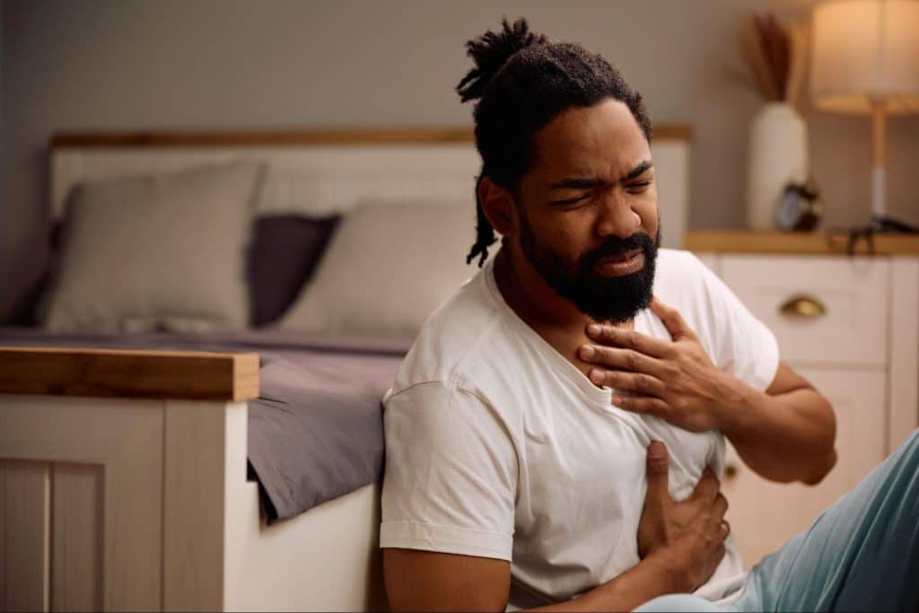 man with hands on chest and stomach in pain