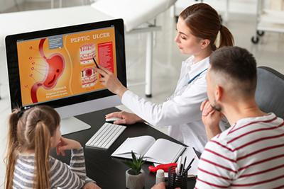 doctor showing patient a diagram on computer screen