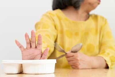 woman pushing away tray of food