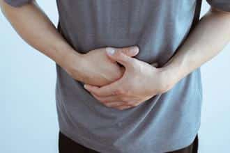 man with hands over stomach